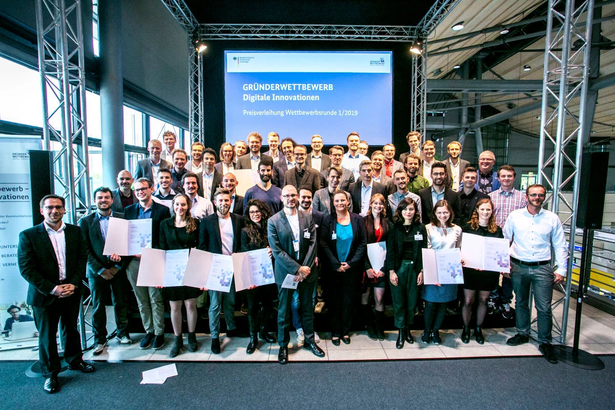 Gruppenfoto aller Preisträgerinnen und Preisträger des Gründerwettbewerbs „Digitale Innovation“ auf der Bühne in Hannover.