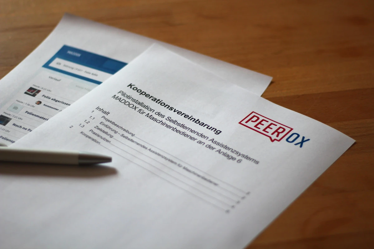 Kooperationsvereinbarung mit Peerox-Logo auf einem Tisch – Symbolbild für partnerschaftliche Zusammenarbeit.