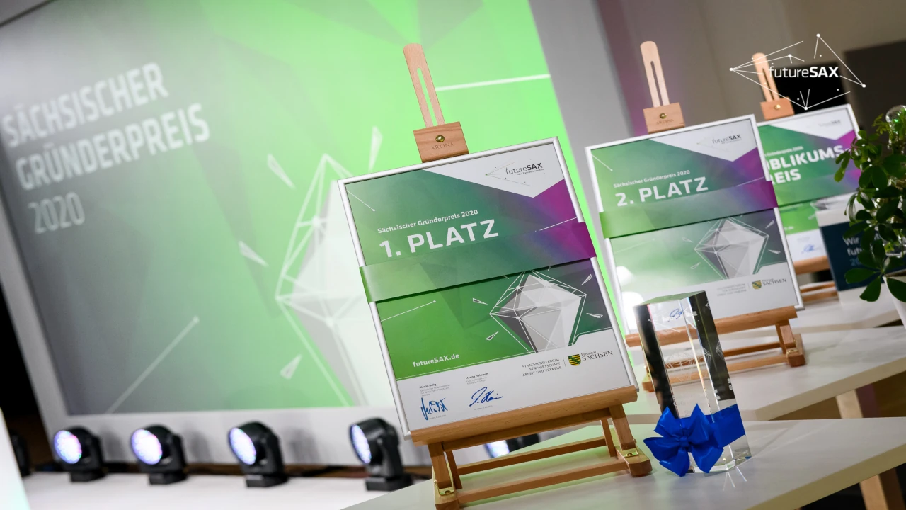 Pokale und Urkunden für den Sächsischen Gründerpreis 2020 auf einem Präsentationstisch arrangiert.